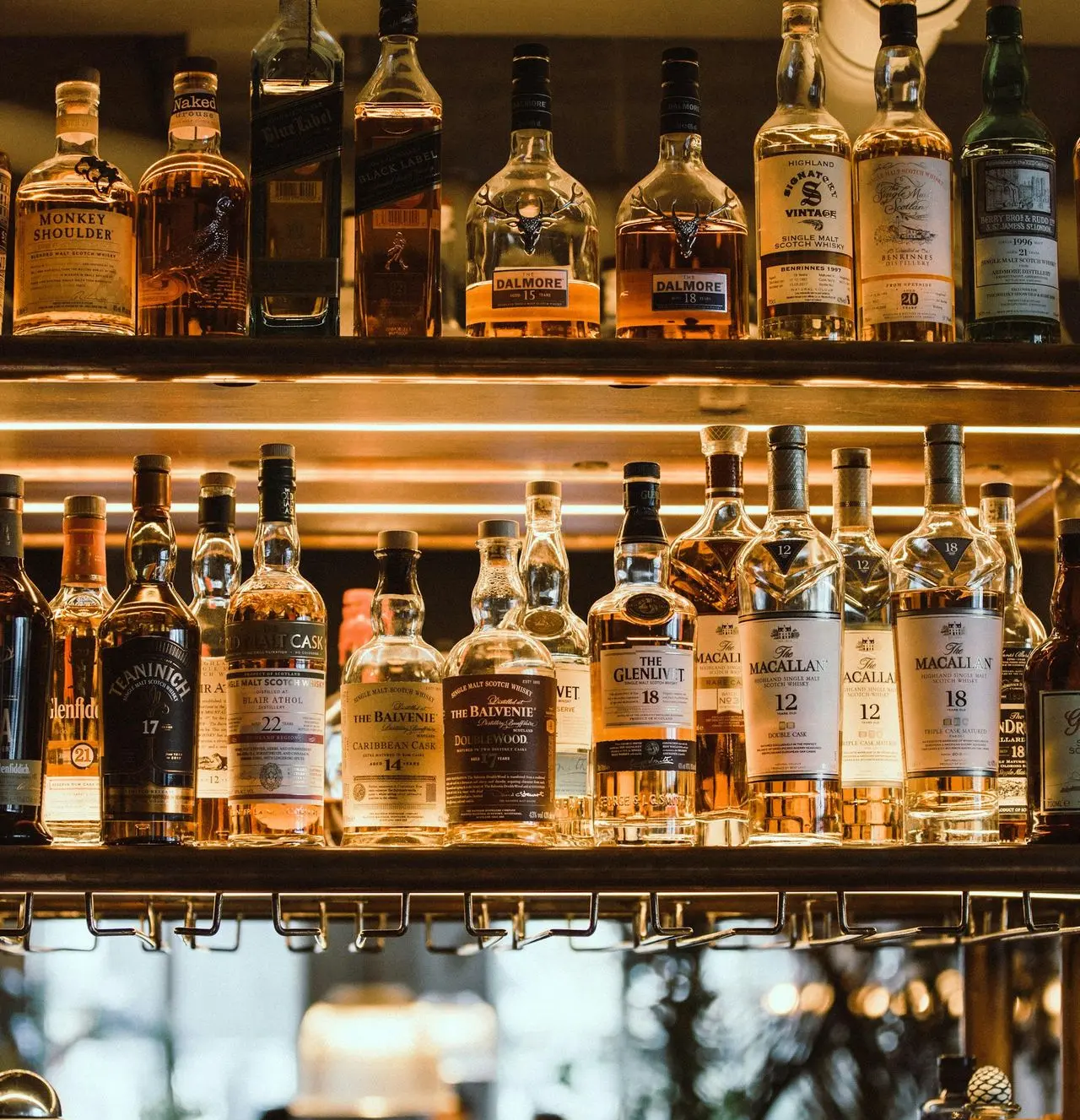 clear glass bottles on brown wooden shelf