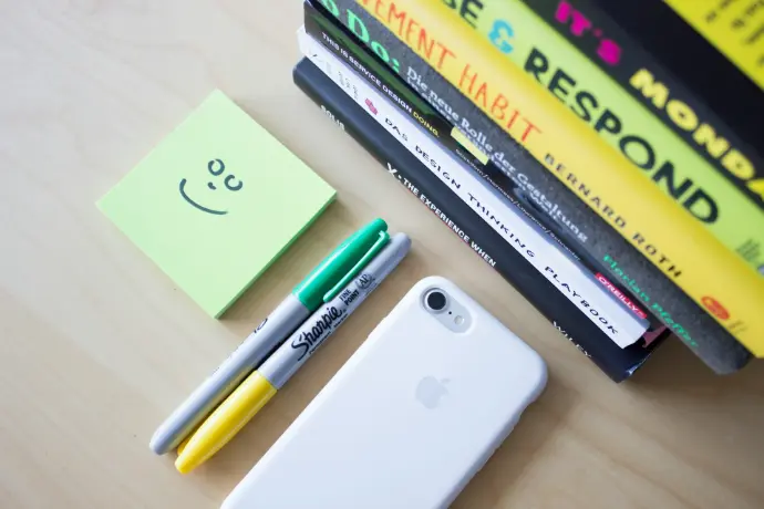 two Sharpie markers beside iPhone and sticky notes