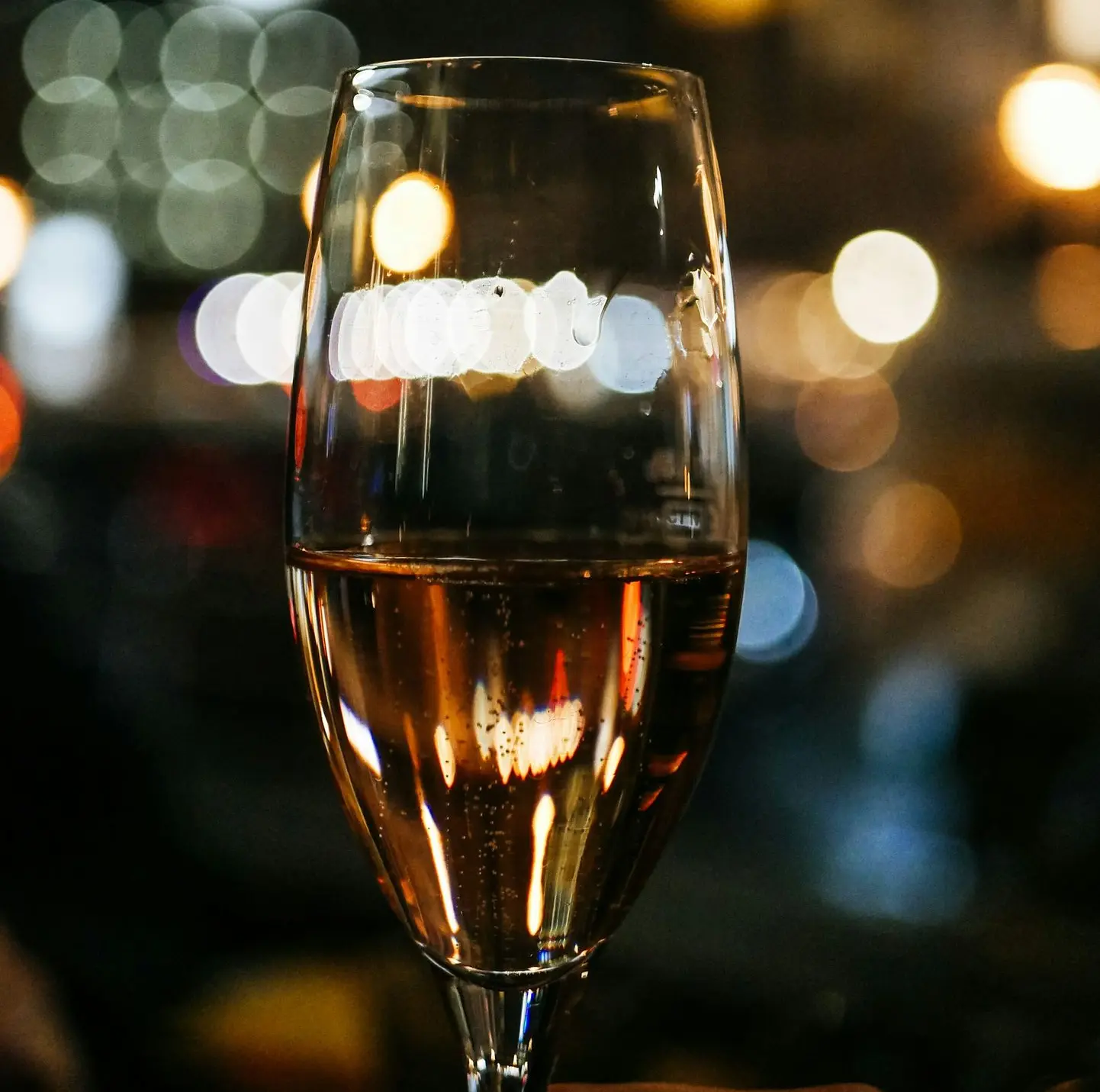 bokeh photography of clear long-stem wine glass