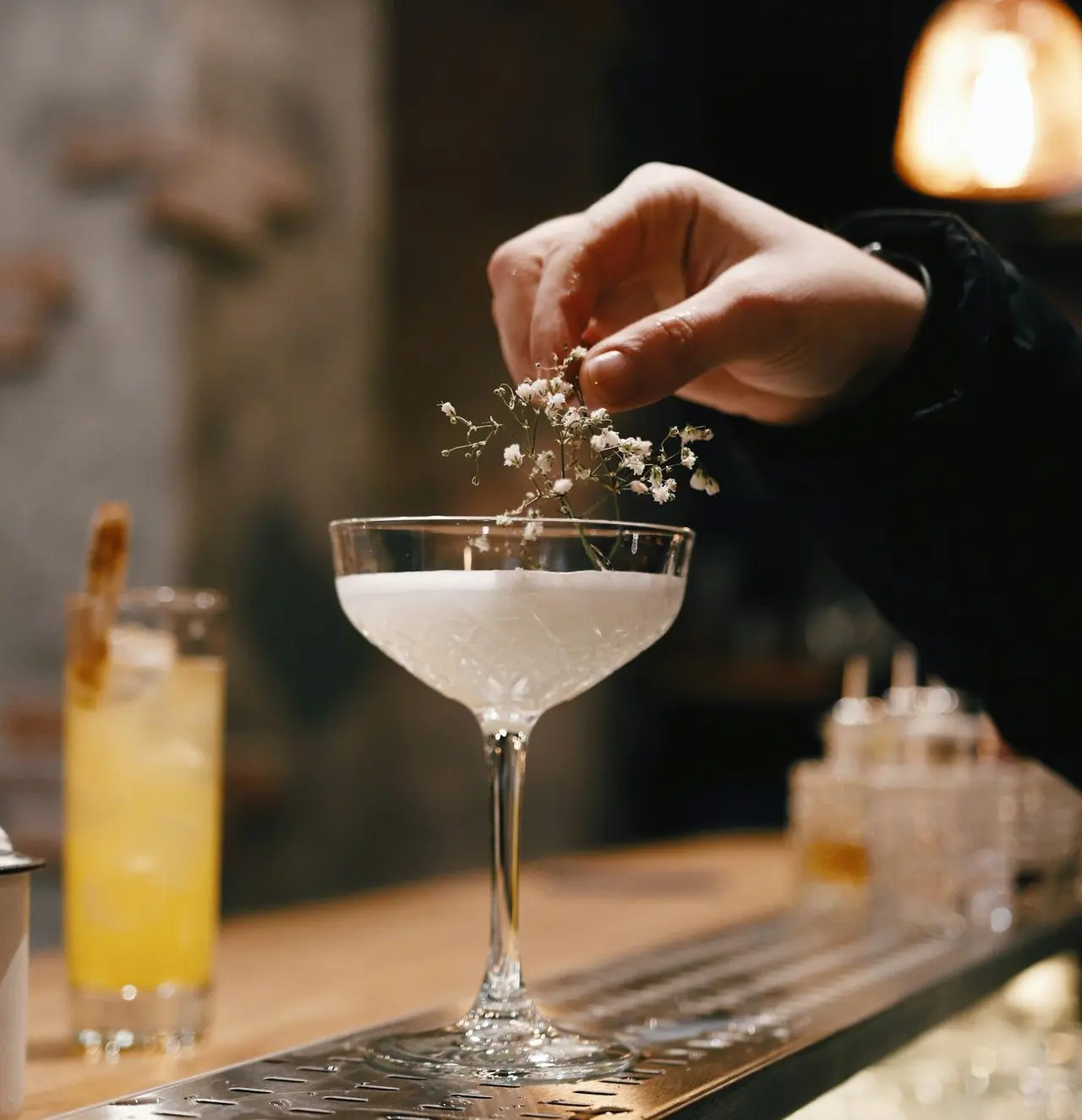 person holding clear wine glass with white liquid